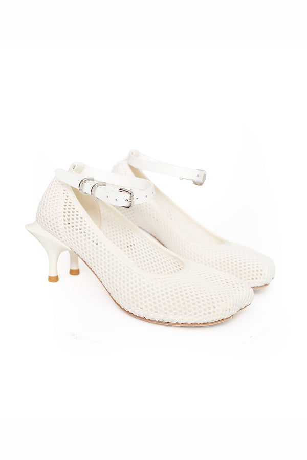 A pair of off-white mesh high-heeled shoes with ankle straps and silver buckles, displayed on a clean white background.