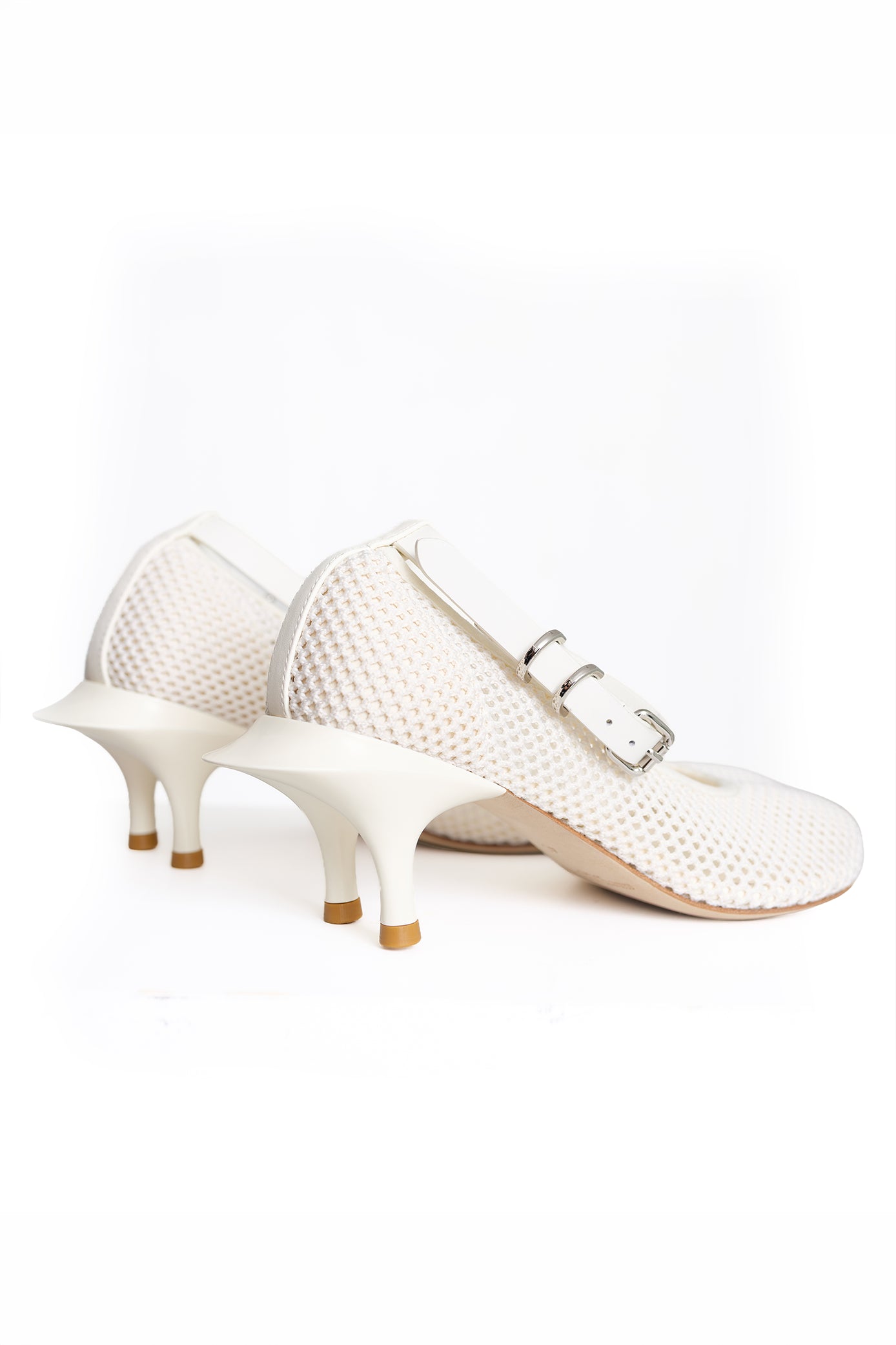 A pair of women's Mary Jane-style heels in off-white, featuring a textured mesh upper, a low kitten heel, and a double-buckle strap design.