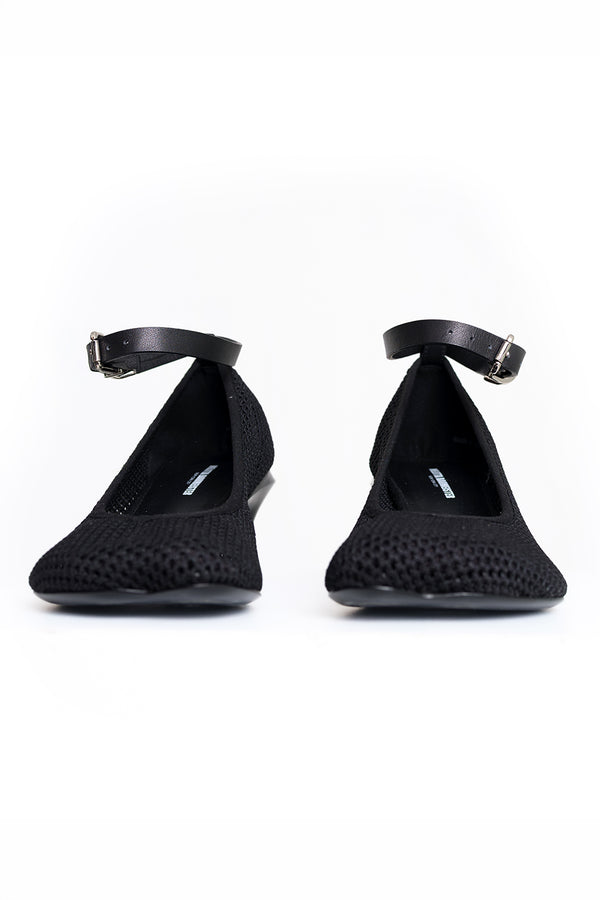 A pair of black Mary Jane flats with a textured knit upper and an ankle strap, shown from the front against a white background.