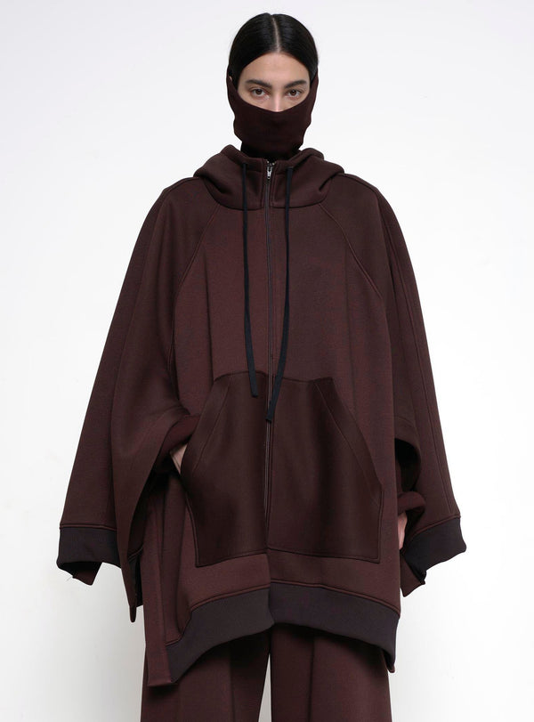 BRUNETTE-WOMAN-LOOKING-STRAIGHT-CAMERA-WEARING-BIG-ZIP-UP-HOODIE-BROWN-AND-TURTLENECK-ABOVE-NOSE-ZOOMED-IN-ABOVE-WAIST-IMAGE