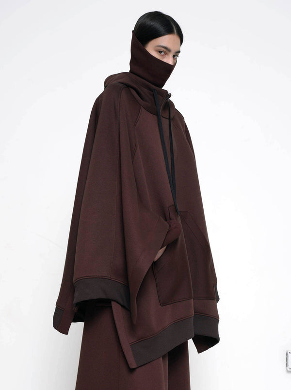 BRUNETTE-WOMAN-SIDE-EYEING-CAMERA-WEARING-BIG-ZIP-UP-HOODIE-BROWN-AND-TURTLENECK-ABOVE-NOSE-ZOOMED-IN-ABOVE-WAIST-IMAGE