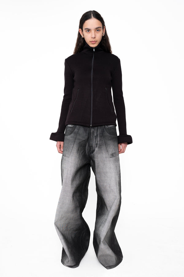 female-is-wearing-black-zip-up-and-grey-oversized-denim-pants-with-black-spray-paint-on-white-background-full-body-front