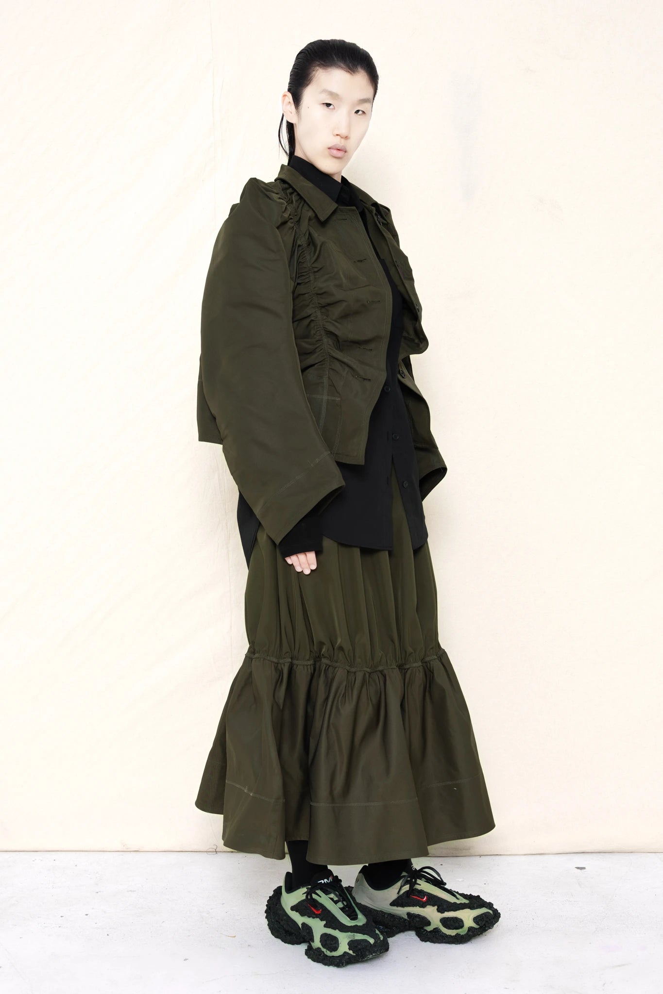 PERSON-WEARING-MOSS-RUCHED-JACKET-OVER-BLACK-BUTTON-DOWN-WITH-MOSS-RUCHED-SKIRT-AND-CUSTOMIZED-SNEAKERS-THREE-QUARTER-VIEW