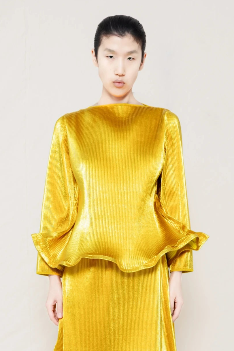 PERSON-WEARING-GOLD-RIPPLE-PLEAT-ZIG-ZAG-HEM-TOP-AND-MATCHING-RIPPLE-PLEAT-ZIG-ZAG-HEM-SKIRT-CLOSE-UP-FRONT-VIEW