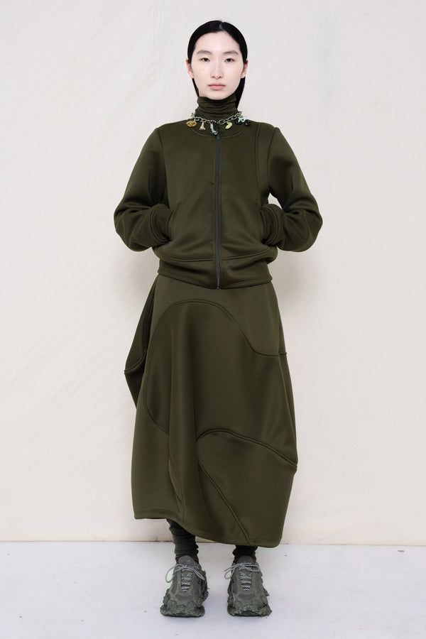 PERSON-WEARING-MOSS-WAVY-ZIP-UP-WITH-MATCHING-WAVY-SEAM-SKIRT-ACCESSORIZED-WITH-MB-CHARM-NECKLACE-AND-CUSTOMIZED-SNEAKERS-FRONT-VIEW