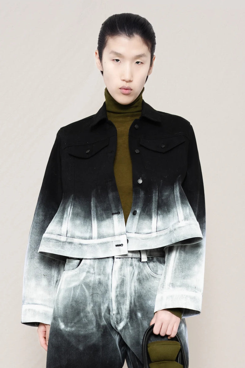 PERSON-WEARING-CROPPED-WHITE-OMBRE-PAINTED-BLACK-PANTS-AND-JACKET-HOLDING-MOSS-HOT-WATER-BOTTLE-SHAPED-BAG-CLOSE-UP-FRONT-VIEW
