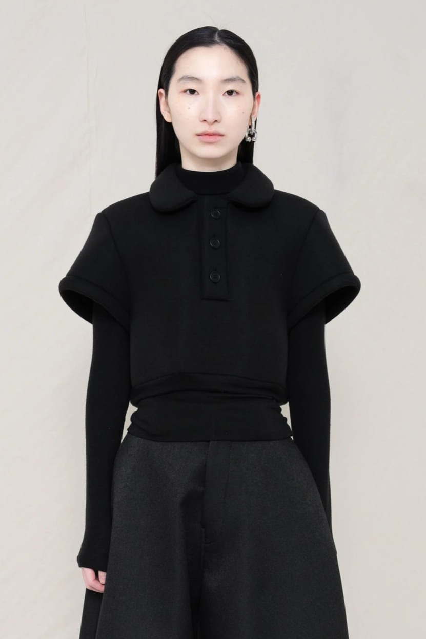 PERSON-WEARING-BLACK-FOAMY-POLO-WITH-BLACK-LONG-SLEEVE-TURTLENECK-UNDER-AND-BLACK-CULOTTE-CLOSE-UP-FRONT-VIEW