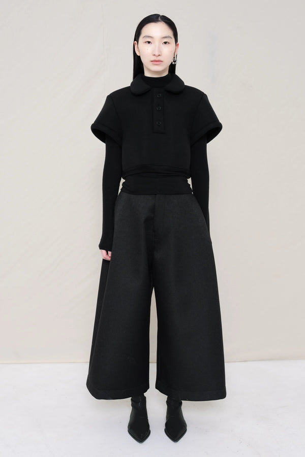PERSON-WEARING-BLACK-FOAMY-POLO-WITH-BLACK-LONG-SLEEVE-TURTLENECK-UNDER-AND-BLACK-CULOTTES-WITH-BLACK-FLAT-POINTY-BOOTS-FRONT-VIEW
