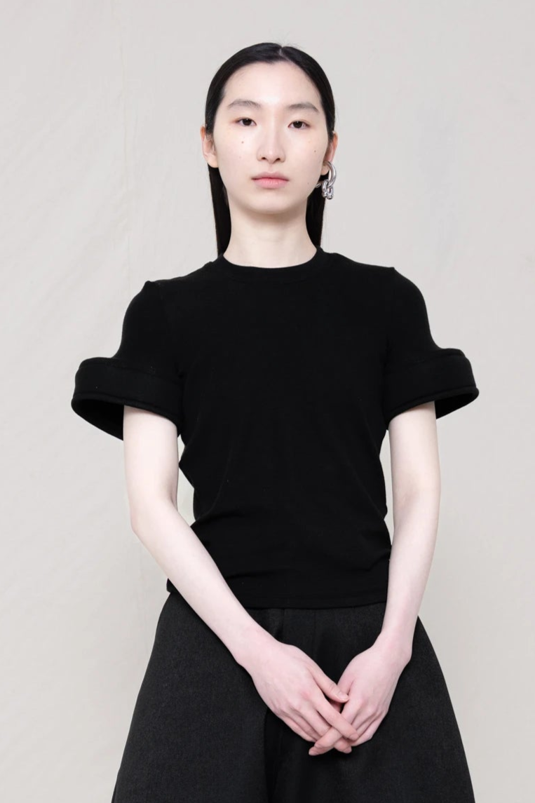 PERSON-WEARING-BLACK-TEE-WITH-FOAM-SLEEVE-CUFFS-AND-BLACK-PANTS-CLOSE-UP-FRONT-VIEW