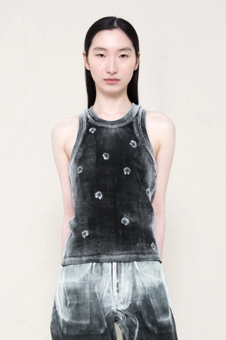 PERSON-WEARING-BLACK-TANK-TOP-WITH-WHITE-PIERCING-PRINT-PAINTED-ON-WITH-OMBRE-STYLE-PAINTED-PANTS-CLOSE-UP-FRONT-VIEW