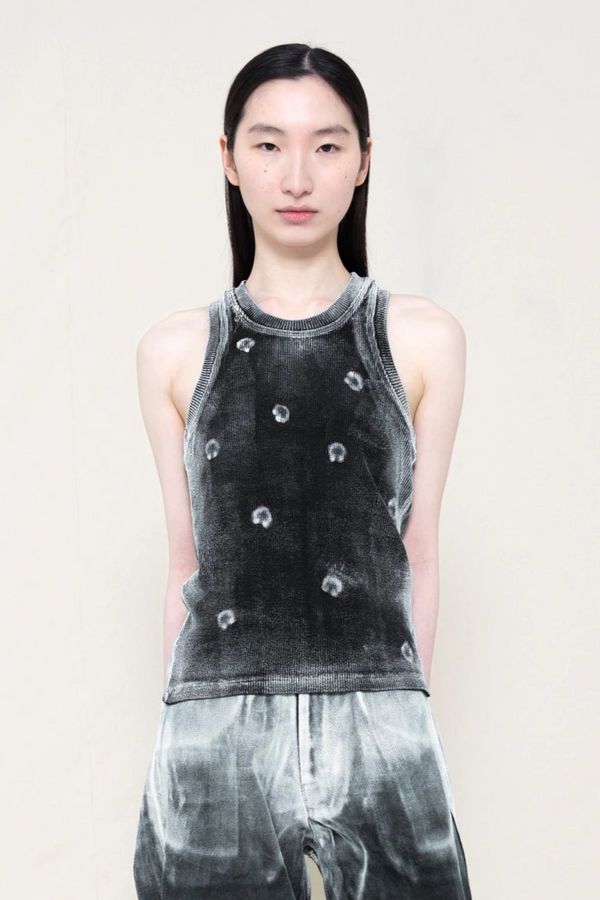 PERSON-WEARING-BLACK-TANK-TOP-WITH-WHITE-PIERCING-PRINT-PAINTED-ON-WITH-OMBRE-STYLE-PAINTED-PANTS-CLOSE-UP-FRONT-VIEW