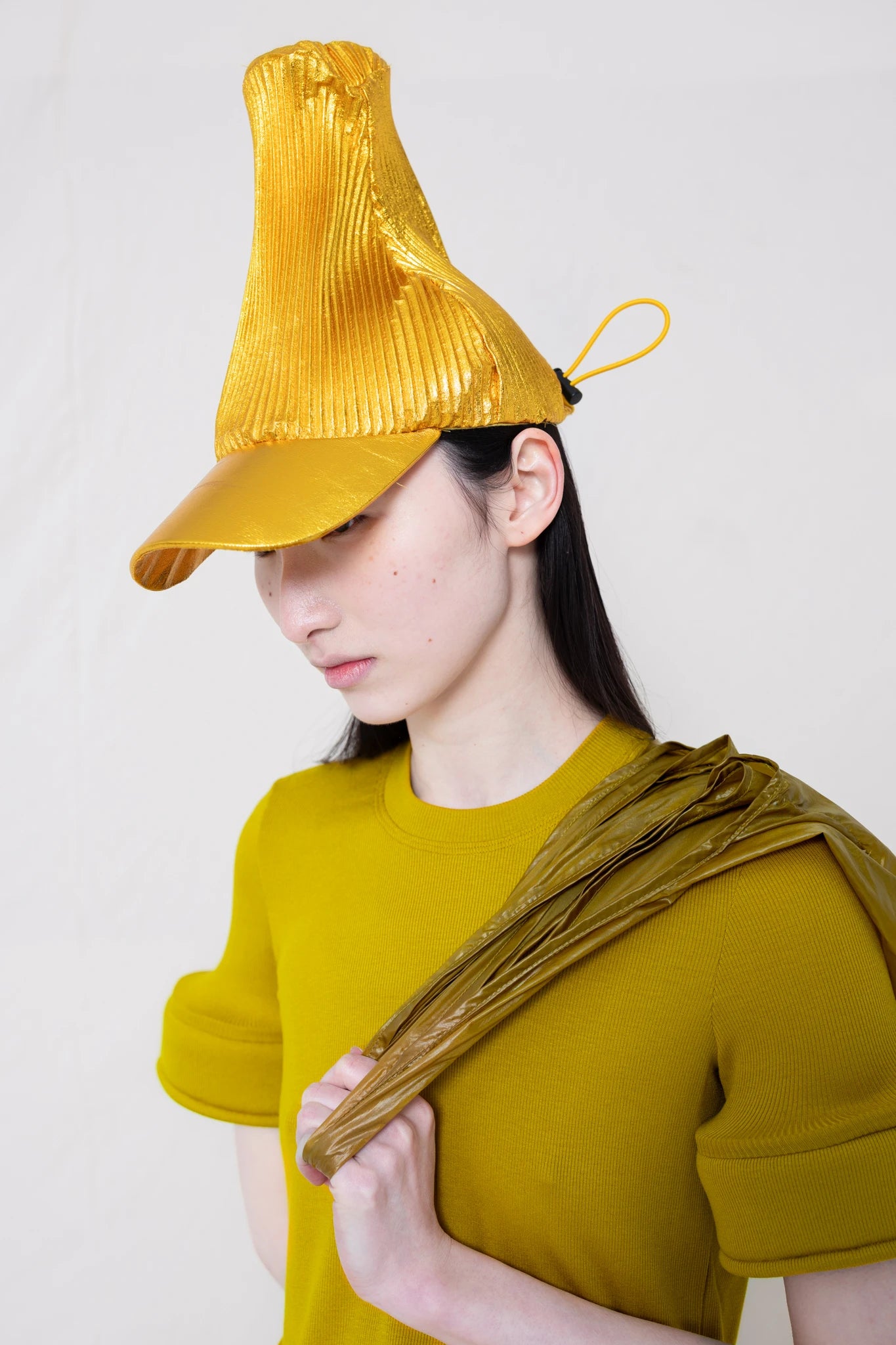 PERSON-WEARING-POINTY-PLEATED-GOLD-CAP-CLOSE-UP-THREE-QUARTER-VIEW