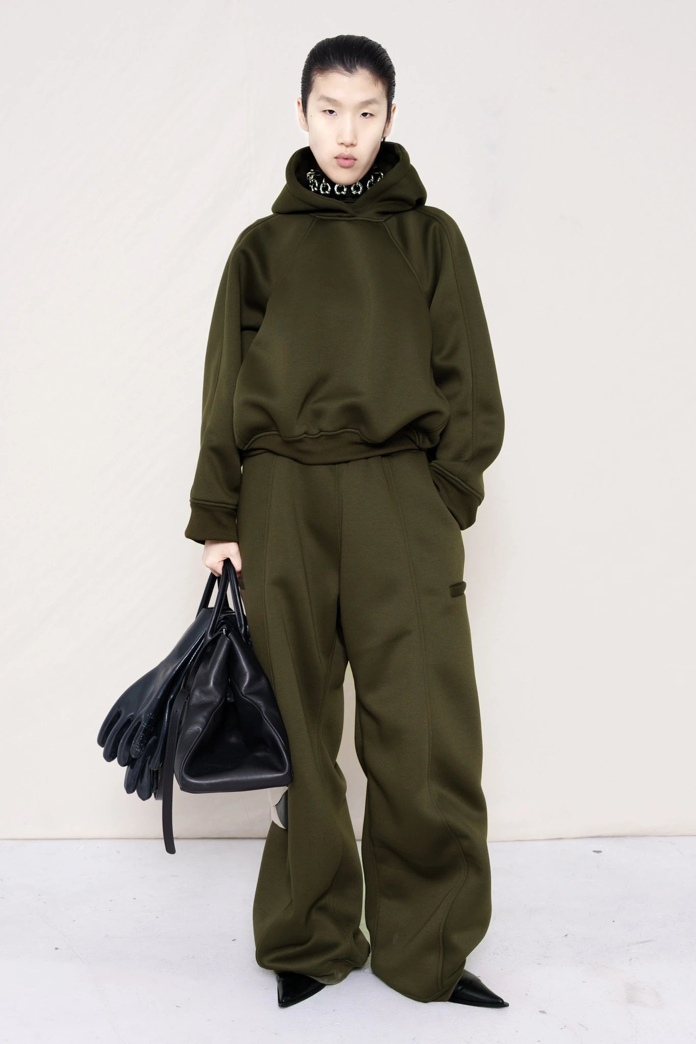 PERSON-WEARING-MOSS-CROPPED-HOODIE-WITH-MATCHING-MOSS-ROUND-LEG-LOUNGEPANTS-AND-PIERCED-CHOKER-WITH-BLACK-FLAT-POINTY-BOOTS-HOLDING-BLACK-COWHIDE-A-LINE-SHOPPER-BAG-FRONT-VIEW