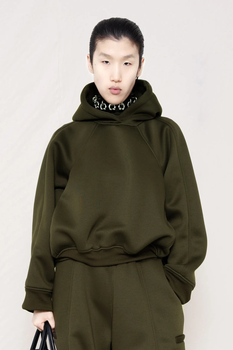 PERSON-WEARING-MOSS-CROPPED-HOODIE-WITH-MATCHING-MOSS-ROUND-LEG-LOUNGEPANTS-AND-PIERCED-CHOKER-WITH-BLACK-FLAT-POINTY-BOOTS-HOLDING-BLACK-COWHIDE-A-LINE-SHOPPER-BAG-CLOSE-UP-FRONT-VIEW