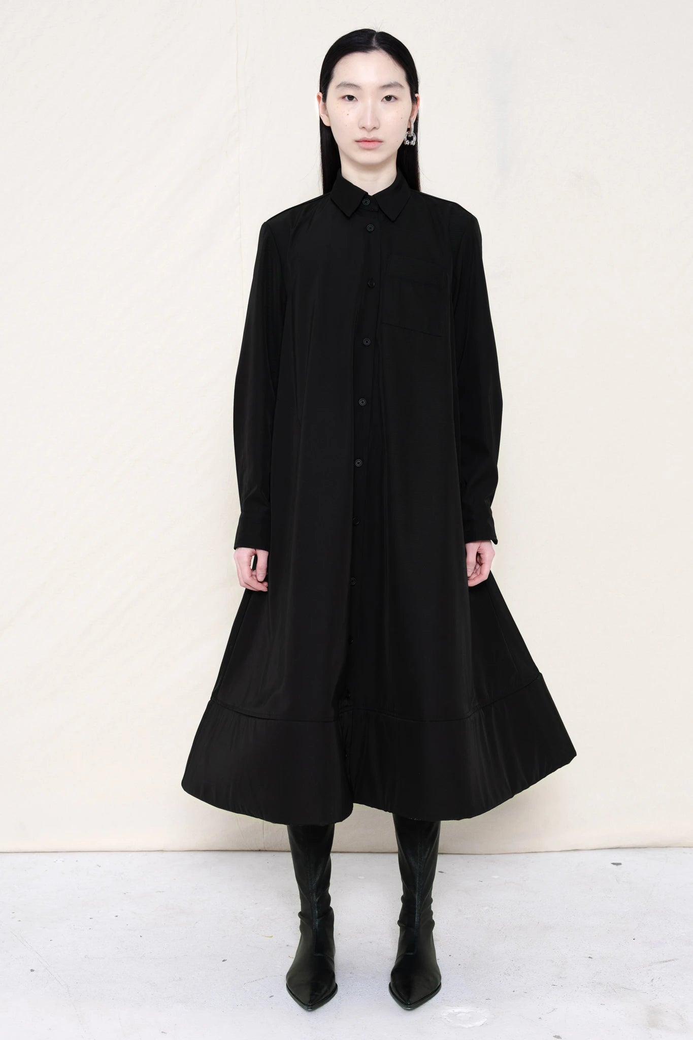 PERSON-WEARING-BLACK-COLLARED-FOAM-BOTTOM-BUTTON-DOWN-SHIRT-DRESS-WITH-BLACK-FLAT-POINTY-BOOTS-FRONT-VIEW