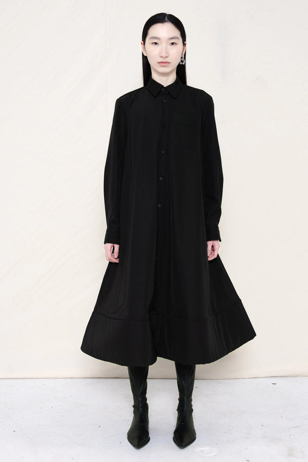 PERSON-WEARING-BLACK-COLLARED-FOAM-BOTTOM-BUTTON-DOWN-SHIRT-DRESS-WITH-BLACK-FLAT-POINTY-BOOTS-FRONT-VIEW