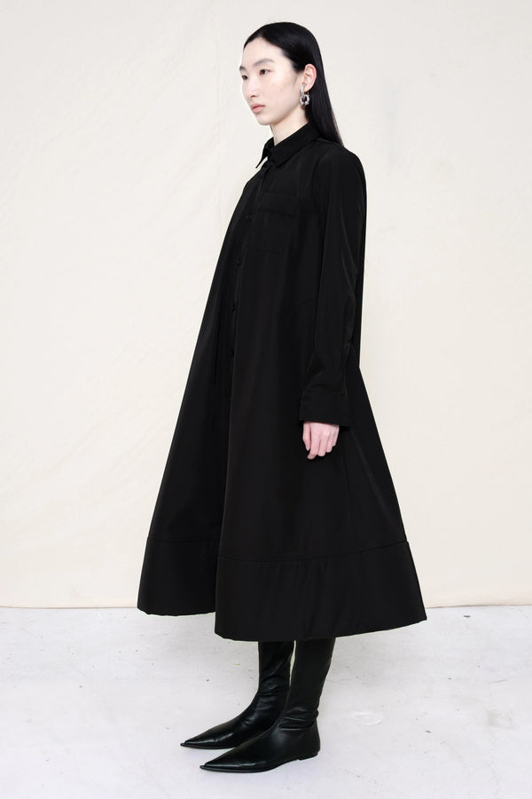 PERSON-WEARING-BLACK-COLLARED-FOAM-BOTTOM-BUTTON-DOWN-SHIRT-DRESS-WITH-BLACK-FLAT-POINTY-BOOTS-THREE-QUARTER-VIEW