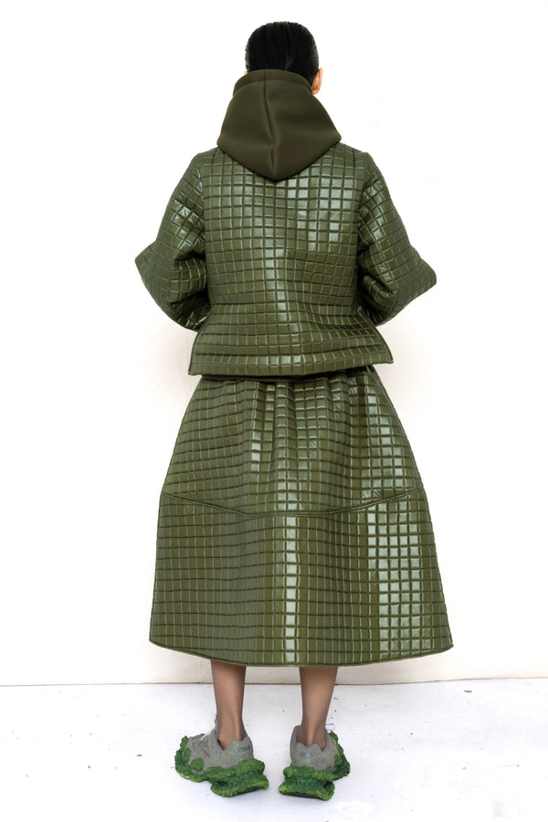 PERSON-WEARING-MOSS-GREEN-COLORED-QUILTED-JACKET-WITH-POCKETS-AND-COLLAR-OVER-MOSS-GREEN-HOODIE-WITH-MATCHING-QUILTED-A-LINE-SKIRT-AND-MUD-GREEN-COLORED-CUSTOMIZED-NIKE-SNEAKER-BACK-VIEW