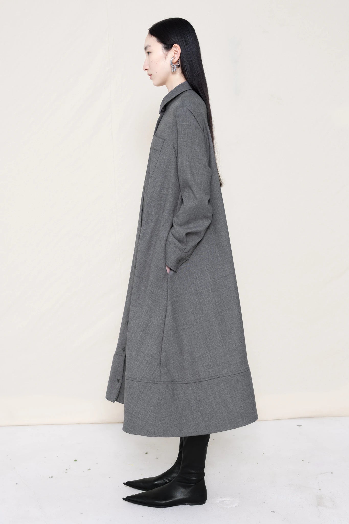PERSON-WEARING-GREY-COLLARED-FOAM-BOTTOM-BUTTON-DOWN-SHIRT-DRESS-WITH-BLACK-FLAT-POINTY-BOOTS-SIDE-VIEW
