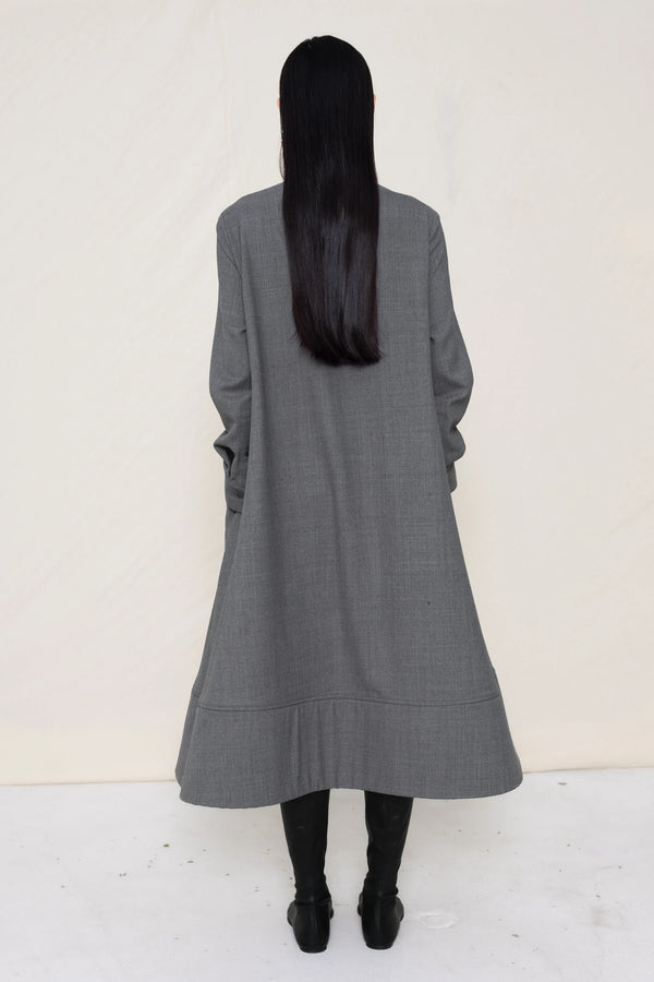 PERSON-WEARING-GREY-COLLARED-FOAM-BOTTOM-BUTTON-DOWN-SHIRT-DRESS-WITH-BLACK-FLAT-POINTY-BOOTS-BACK-VIEW