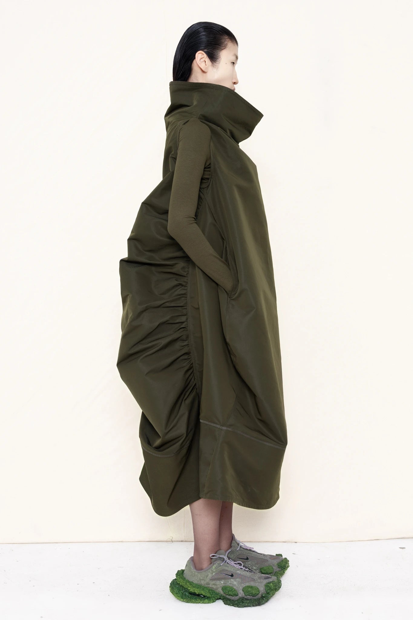 PERSON-WEARING-MOSS-HIGH-COLLAR-DRESS-WITH-RUCHED-BACK-DETAILING-OVER-MATCHING-COLORED-LONGSLEEVE-WITH-CUSTOMIZED-SNEAKERS-SIDE-VIEW