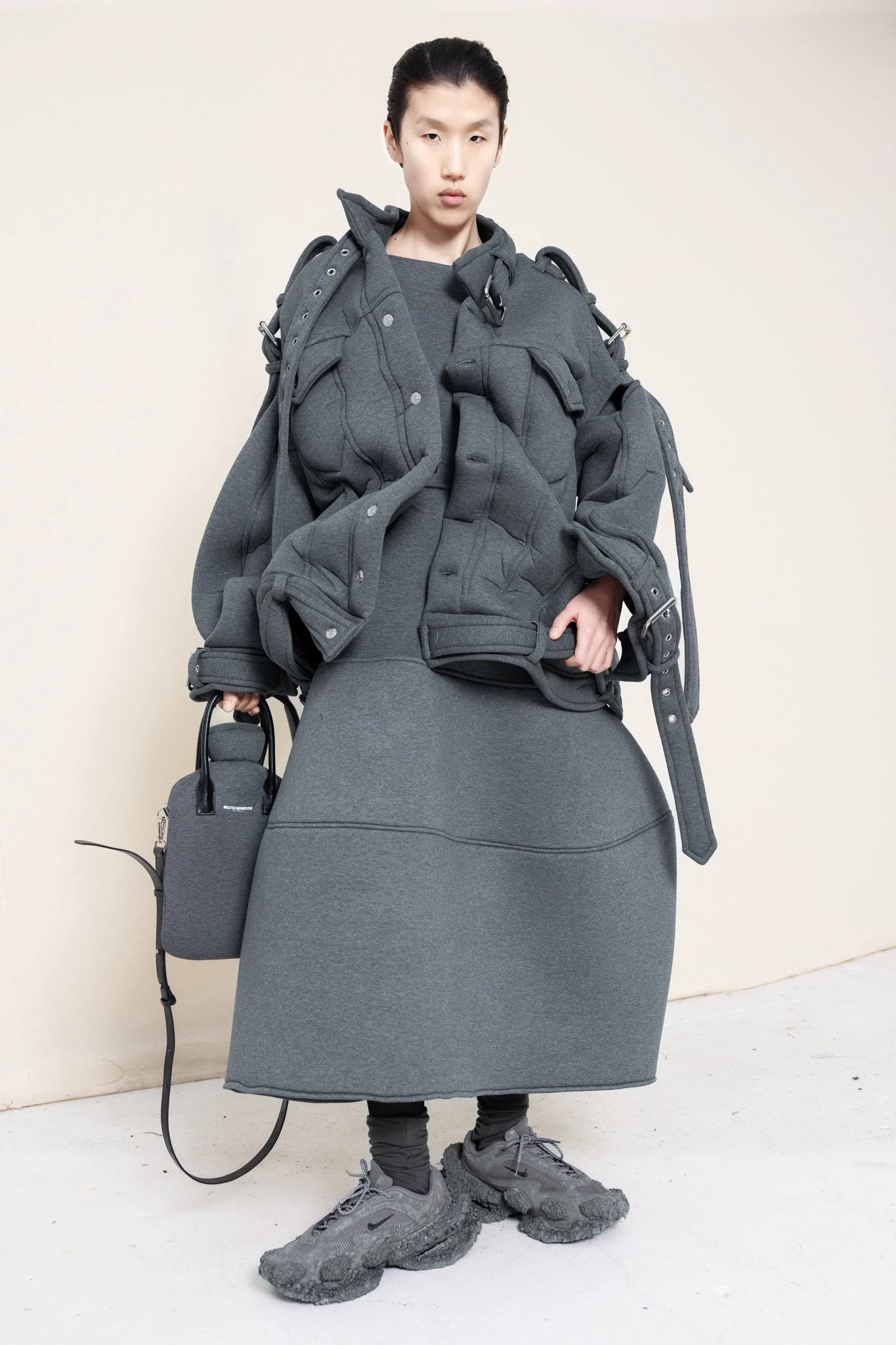 PERSON-WEARING-MELANGE-BELTED-ZIGZAG-JACKET-WITH-MATCHING-MELANGE-FOAMY-BALL-SKIRT-ACCESSORIZED-WITH-MELANGE-HOT-WATER-BOTTLE-BAG-AND-CUSTOMIZED-SNEAKERS-FRONT-VIEW