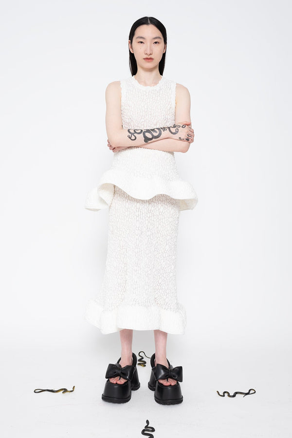 MELITTA-BAUMEISTER-Foam-Ruffle-Skirt-White-WORN-WITH-WHITE-SLEEVELESS-WHITE-RUFFLE-TOP-AND-HIGH-PLATFORM-BLACK-LEATHER-SHOES-BLACK-LONG-HAIR-FEMALE-MODEL-WITH-SNAKE-TATTOOS-ON-RIGHT-ARM