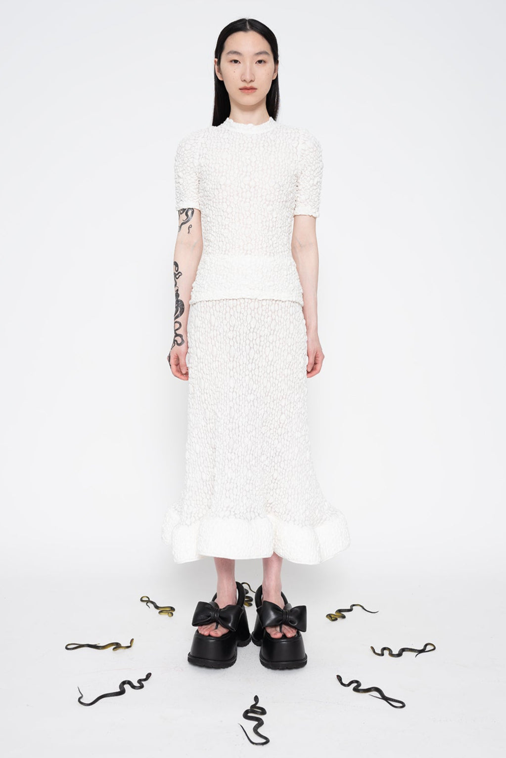 MELITTA-BAUMEISTER-Foam-Ruffle-Skirt-White-FULL-BODY-FRONT-VIEW-WITH-SNAKES-SURROUNDING-MODELS-FEET