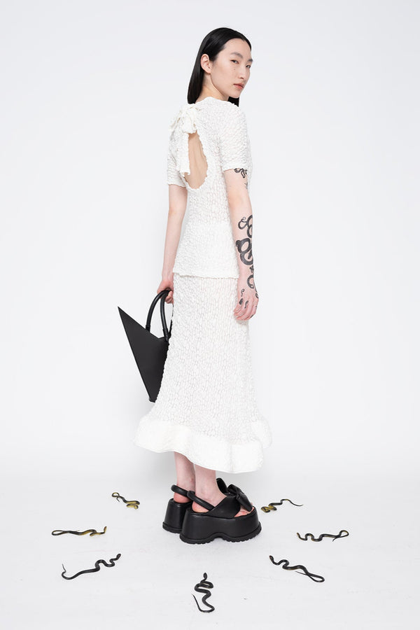 MELITTA-BAUMEISTER-Foam-Ruffle-Skirt-White-SLIGHT-RIGHT-BACK-VIEW-AND-POINTY-SHOULDER-BAG-IN-LEFT-HAND