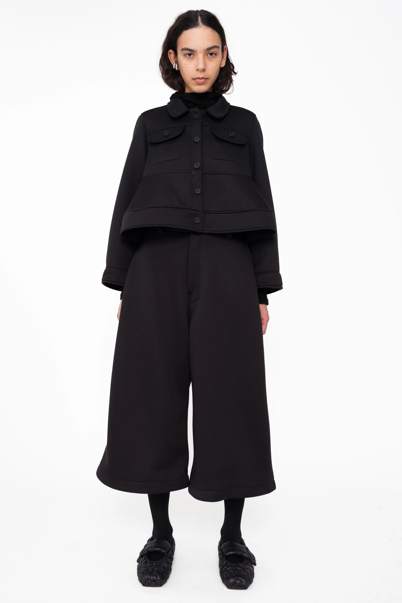 female wearing-black-cropped-jacket-with-pockets-and-spongy-hem-with-black-cropped-pants-on-white-background-full-body-front