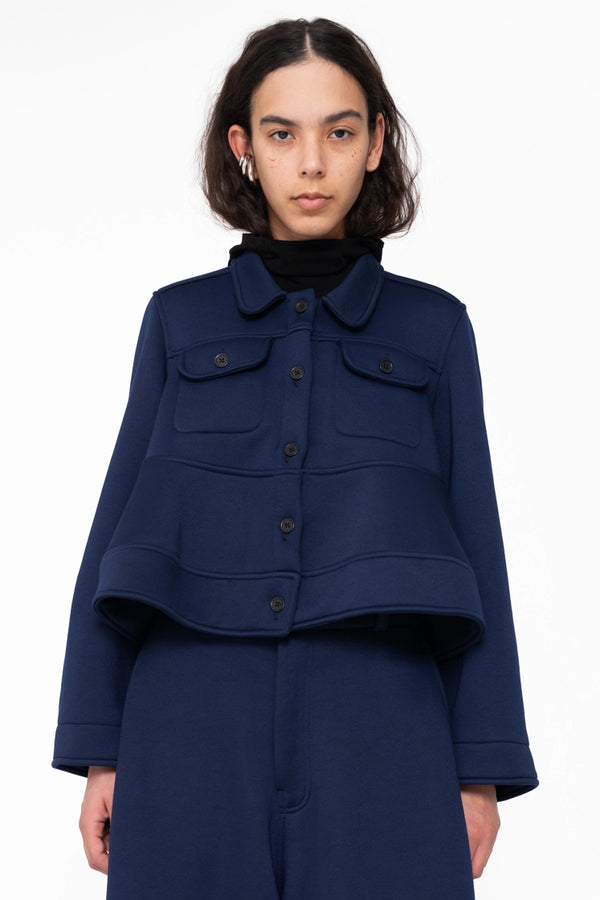 female-wearing-navy-cropped-jacket-with-wavy-hem-and-navy-loungepants-on-white-background-close-up-torso-front