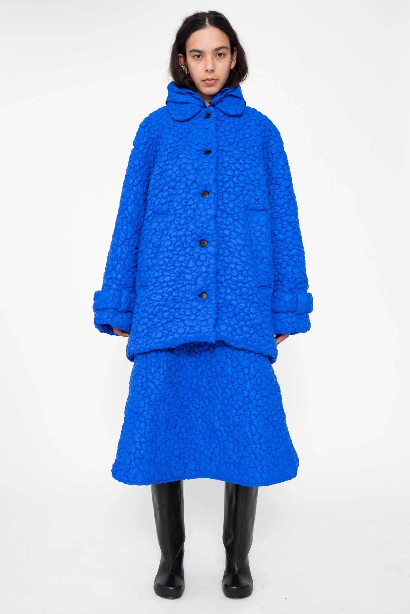 female-wearing-electric-blue-quilted-windbreaker-with-flower-embroidery-on-white-background-full-body-front