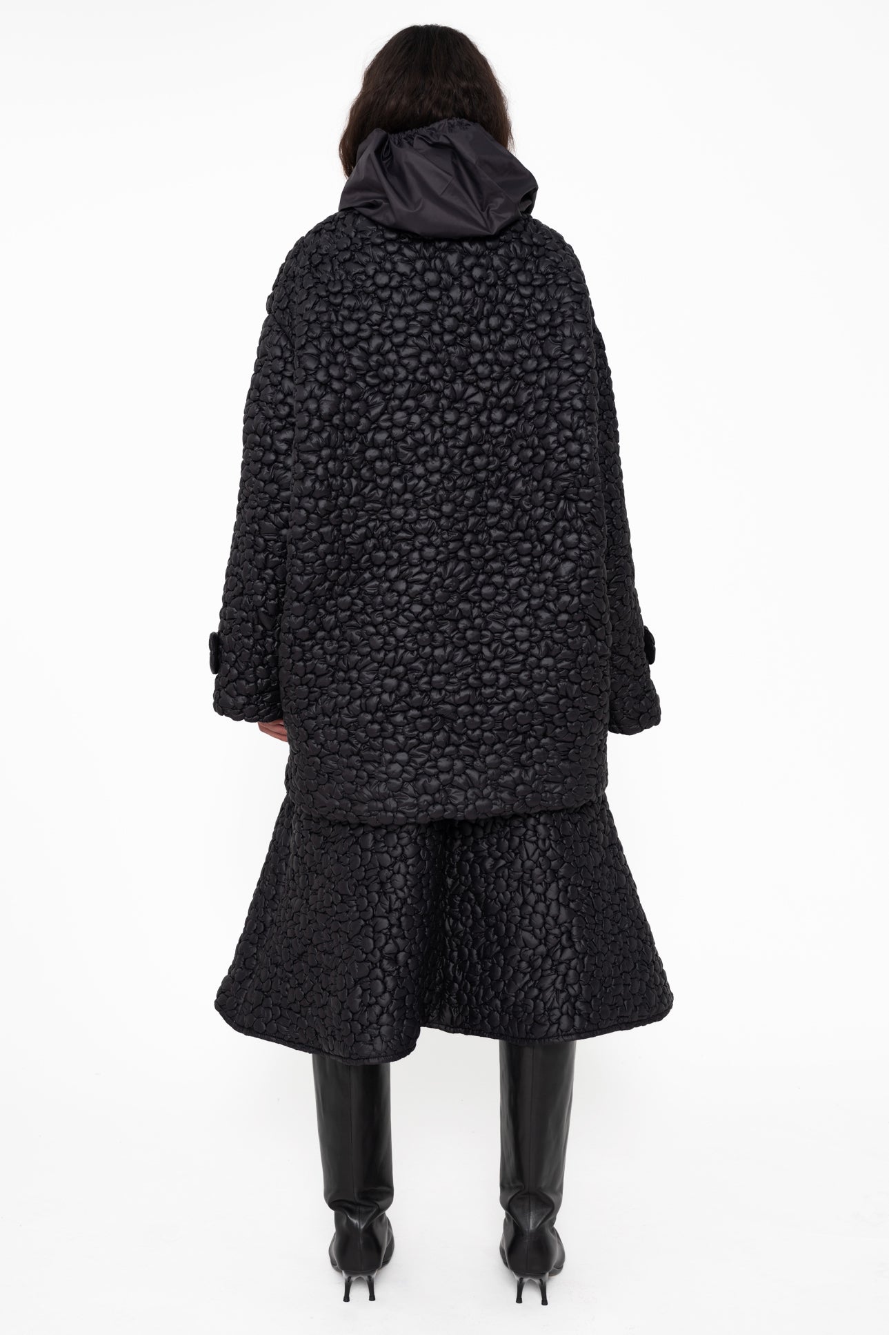 female-wearing-black-quilted-aline-skirt-with-black-quilted-windbreaker-with-flower-embroidery-on-white-background-full-body-back