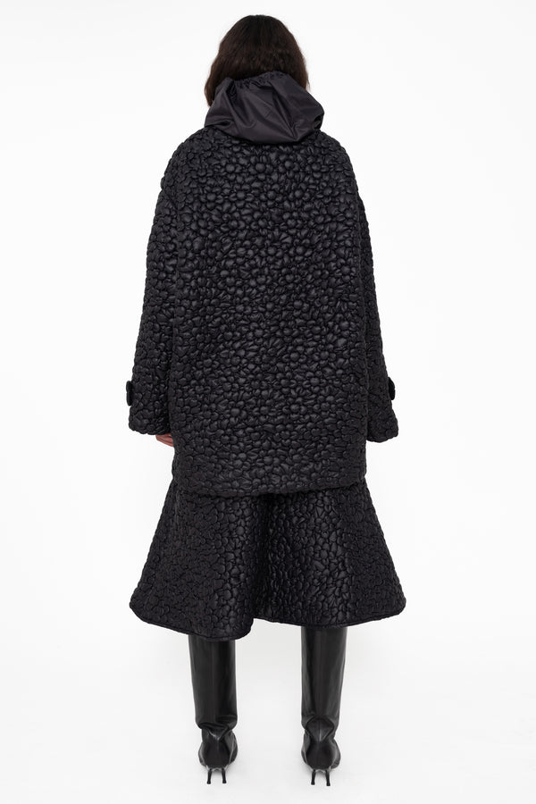 female-wearing-black-quilted-aline-skirt-with-black-quilted-windbreaker-with-flower-embroidery-on-white-background-full-body-back