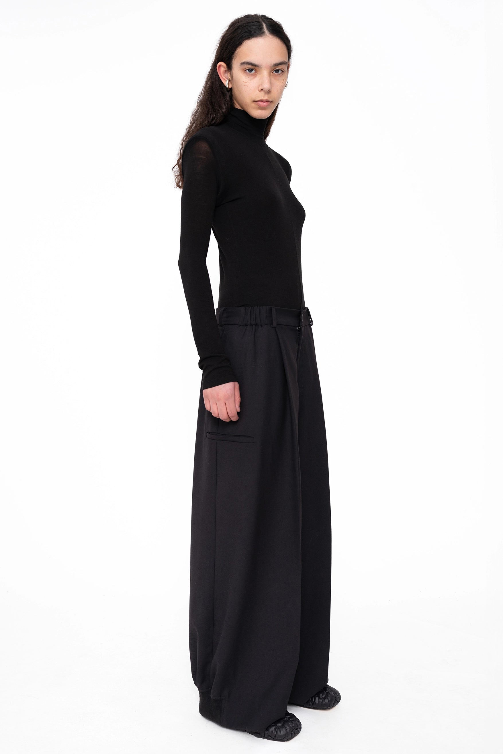 female-wearing-back-longsleeve-turtleneck-with-shoulder-detail-on-white-background-fullbody-three-quarter