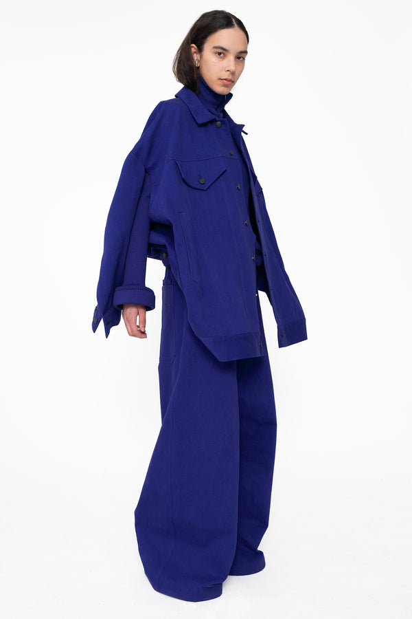 female-wearing-blue-oversized-belted-denim-jacket-with-blue-denim-pants-full-body-three-quarter