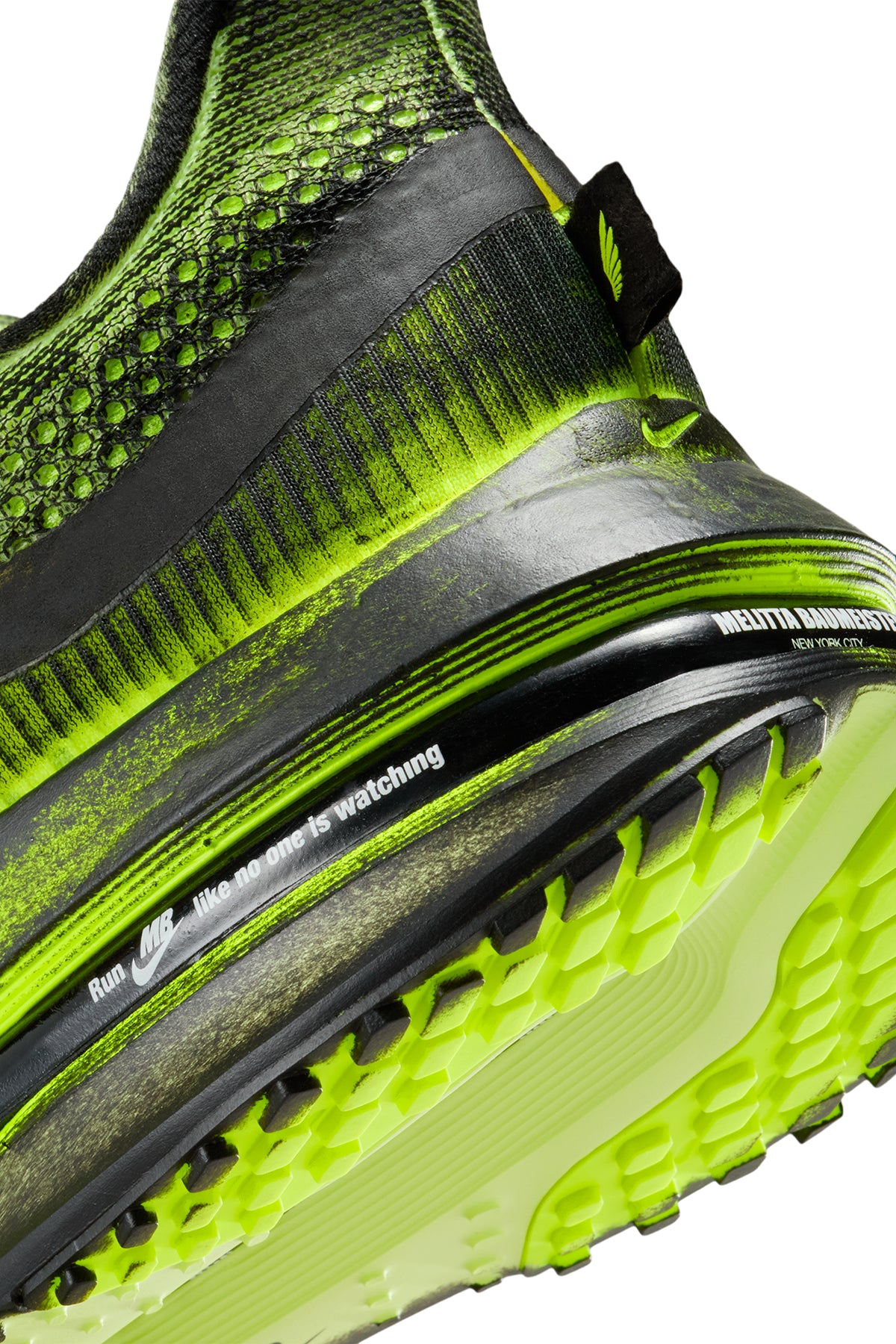 Close-up of a green and black athletic shoe with tread pattern