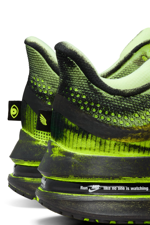 Close-up of a pair of black and green athletic shoes with Nike and MB branding.