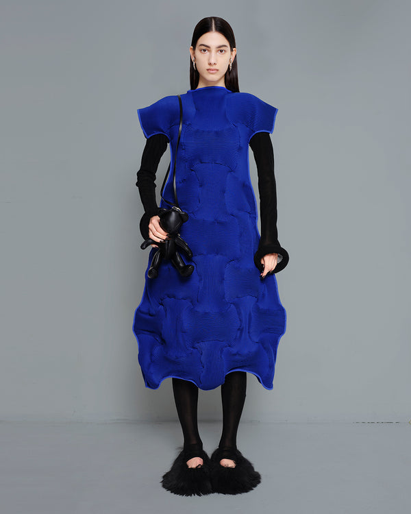 MELITTA-BAUMEISTER-BLACK-TEDDY-TOTE-BAG-LONG-BLACK-HAIR-FEMALE-MODEL-HOLDING-BLACK-TEDDY-BEAR-HANDBAG-WHILE-WEARING-BLUE-PLEATED-SKIRT-BLACK-BODYSUIT-AND-BLACK-FURRY-SHOES