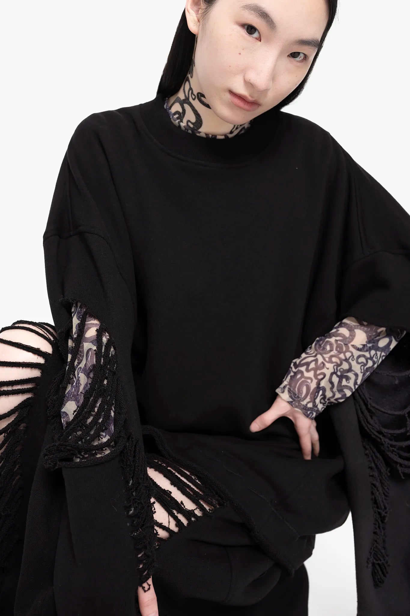 MELITTA-BAUMEISTER-Crewneck-Sweater-Black-MODEL-SITTING-DOWN-LOOKING-STRAIGHT