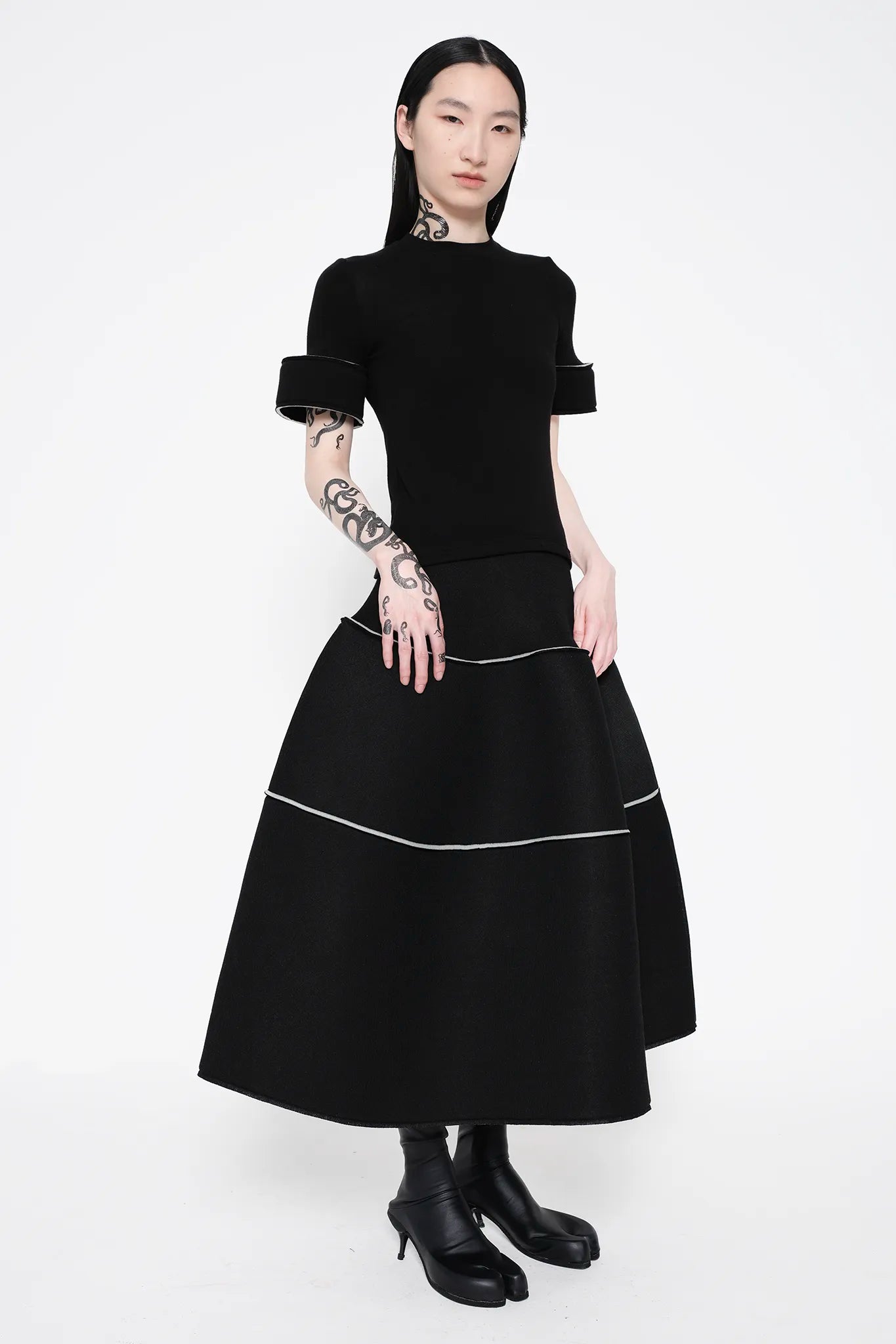 MELITTA-BAUMEISTER-Foam-Cuff-Tee-in-Black-BLACK-LONG-HAIR-FEMALE-MODEL-ALSO-WEARING-BLACK-LEATHER-SHOES-SLIGHT-RIGHT-SIDE-VIEW