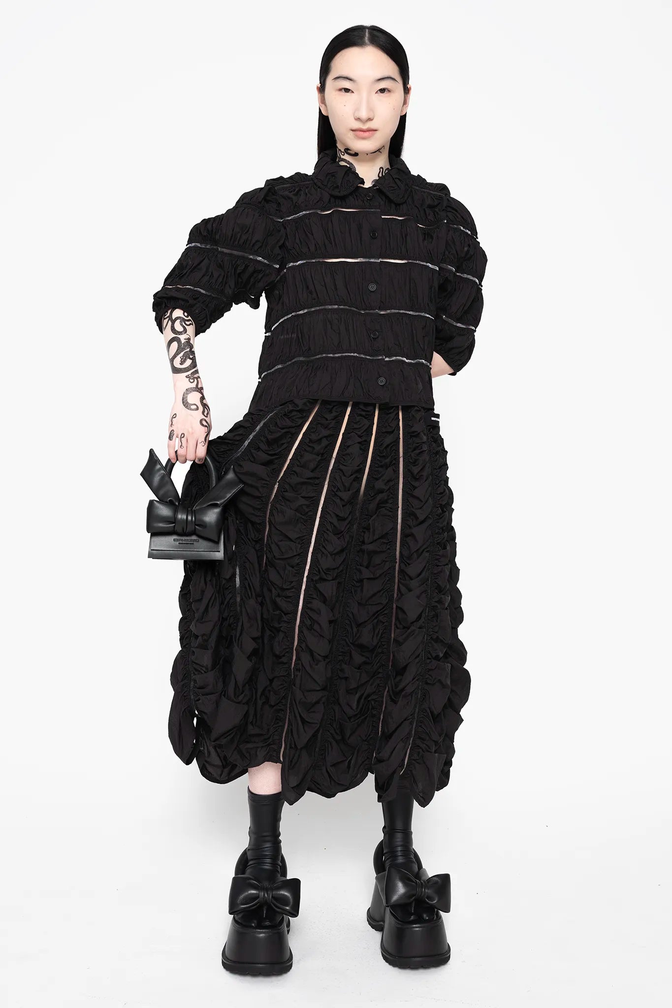 MELITTA-BAUMEISTER-Ruched-A-Line-Skirt-Black-FRONT-VIEW-RIGHT-ARM-WITH-BAG-SLIGHTLY-ELEVATED