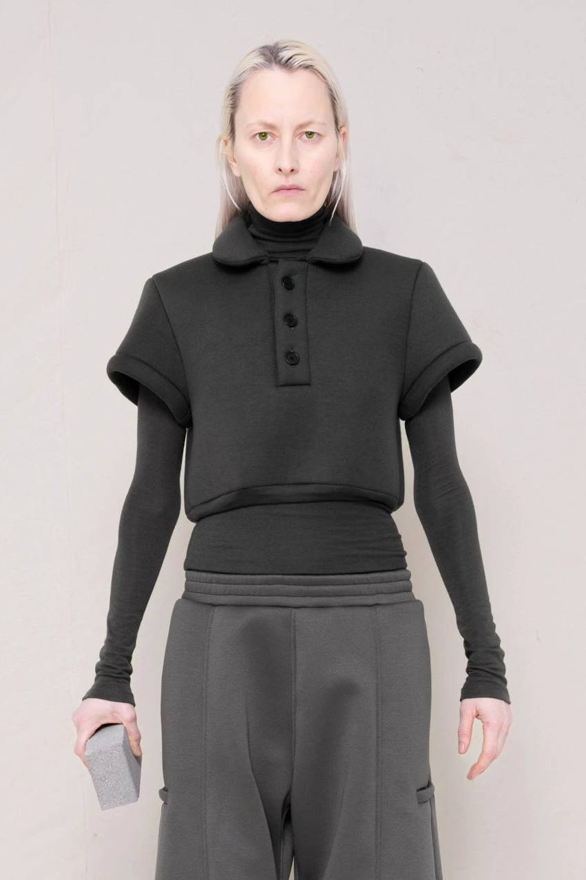 PERSON-WEARING-WARM-GREY-FOAMY-POLO-OVER-MATCHING-LONG-SLEEVE-TURTLENECK-WITH-STONE-GREY-ROUND-LEG-LOUNGEPANTS-HOLDING-GREY-BRICK-CLOSE-UP-FRONT-VIEW