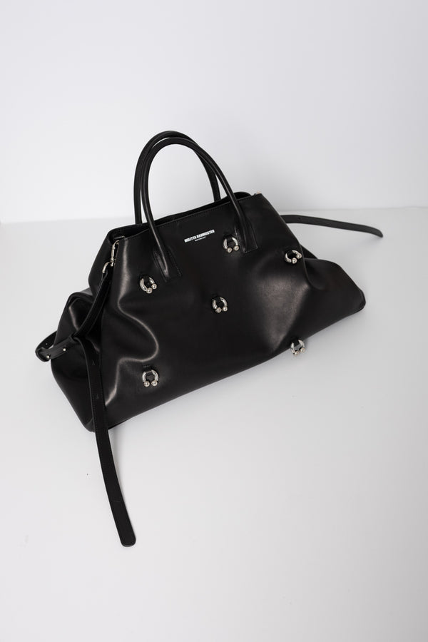 BLACK-COWHIDE-A-LINE-BAG-WITH-SHAOULDER-STRAPS-AND-CROSS-BODY-STRAPS-WITH-PIERCED-DETAIL-THREE-QUARTER-VIEW