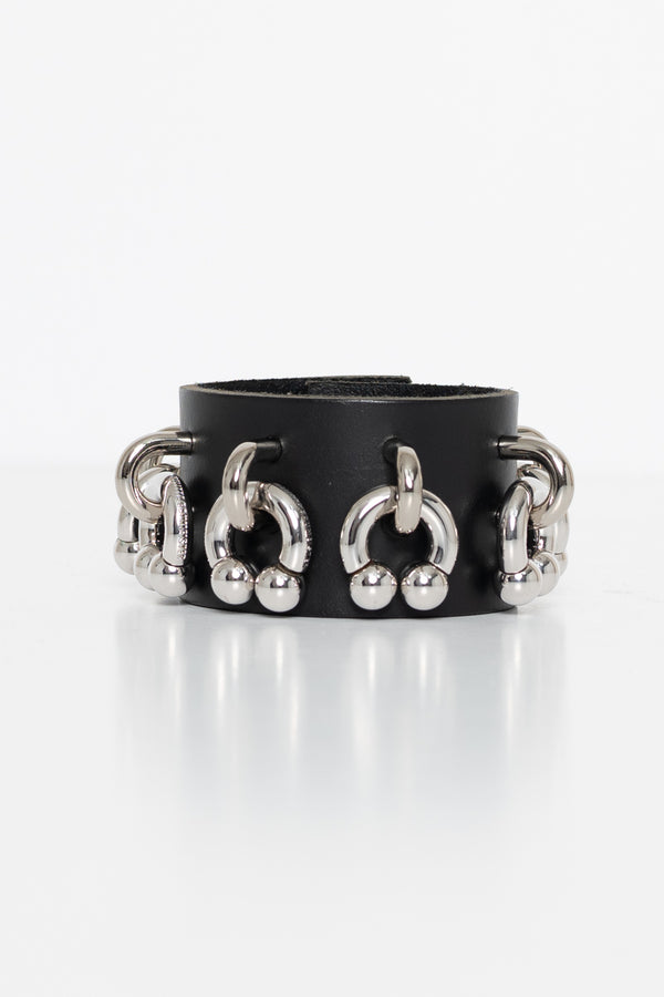 Black leather cuff with silver circular and ball designs on a white background