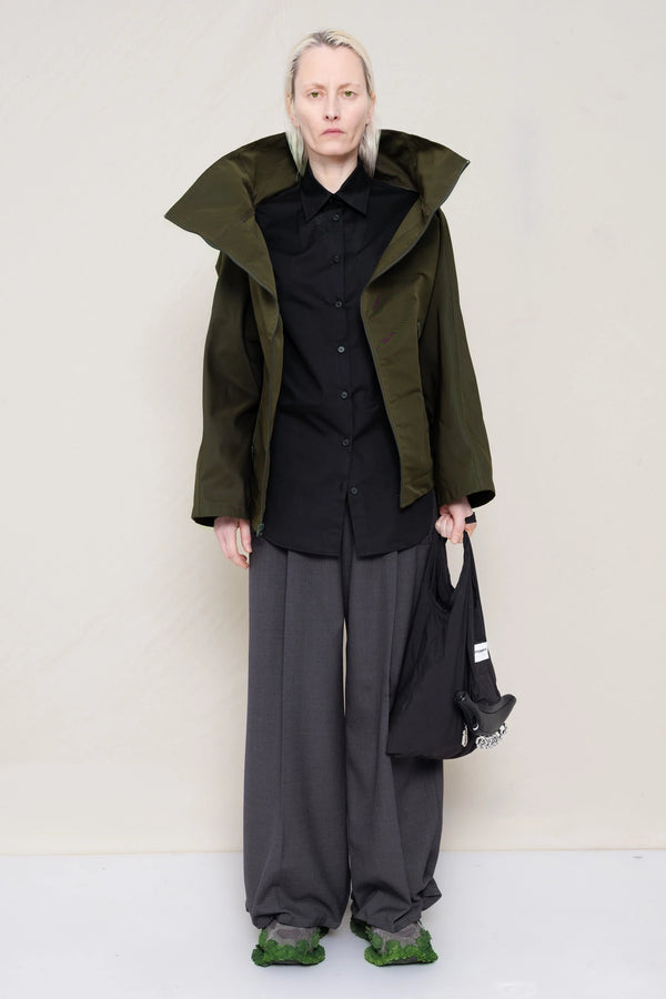 PERSON-WEARING-MOSS-BODY-ZIP-UP-JACKET-WITH-BLACK-BUTTON-DOWN-AND-GREY-TAILORED-PANTS-AND-CUSTOMIZED-SNEAKERS-HOLDING-GREY-BANANA-TOTE-BAG-FRONT-VIEW