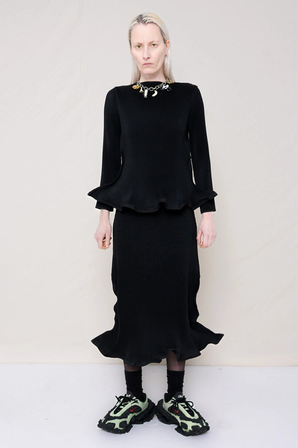 PERSON-WEARING-BLACK-RIPPLE-PLEAT-ZIG-ZAG-HEM-TOP-AND-MATCHING-RIPPLE-PLEAT-ZIG-ZAG-HEM-SKIRT-ACCESSORIZED-WITH-CUSTOMIZED-SNEAKERS-AND-MB-CHARM-NECKLACE-FRONT-VIEW