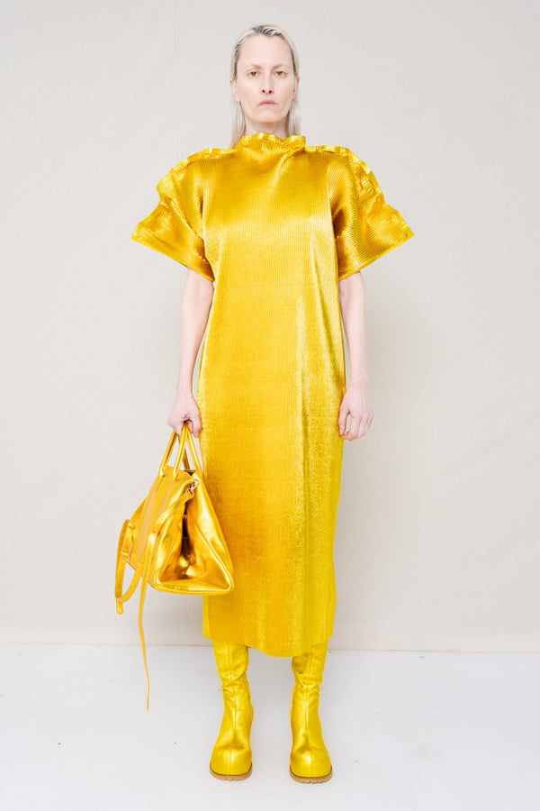 PERSON-WEARING-GOLD-PLEAT-MALLEABLE-SHOULDER-DRESS-WITH-MATCHING-GOLD-COWHIDE-DOUBLE-HEELED-BOOTS-HOLDING-GOLD-A-LINE-SHOPPER-BAG-FRONT-VIEW