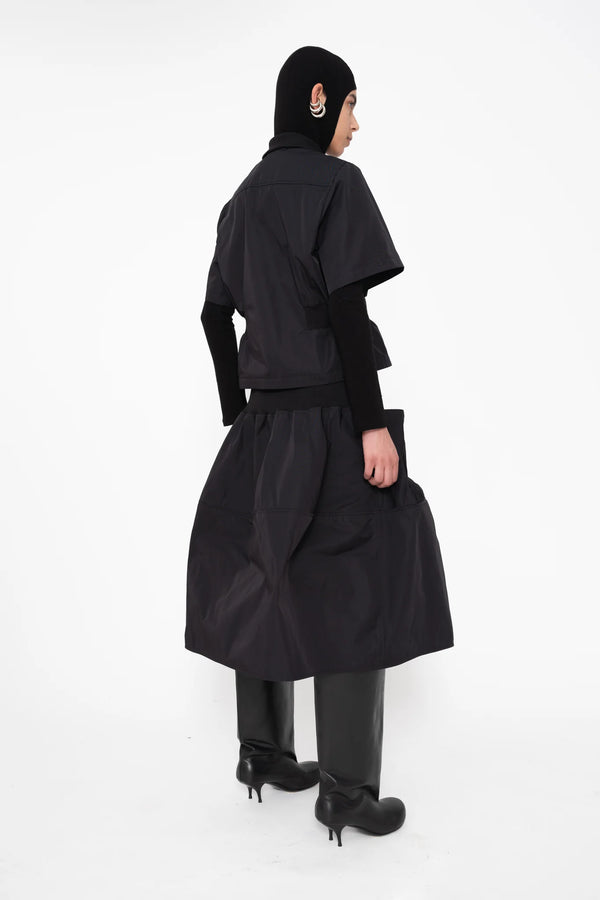 female-wearing-black-bomber-shirt-with-black-midi-skirt-on-white-background-full-body