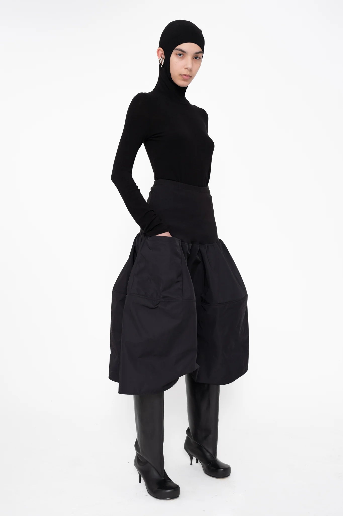 female-wearing-black-balaclava-top-with-ear-cutouts-and-black-midi-skirt-on-white-background-full-body